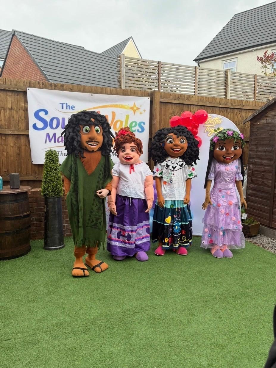 Bruno, Luisa, Mirabel and Isabela lookalike mascots lined up on artificial grass