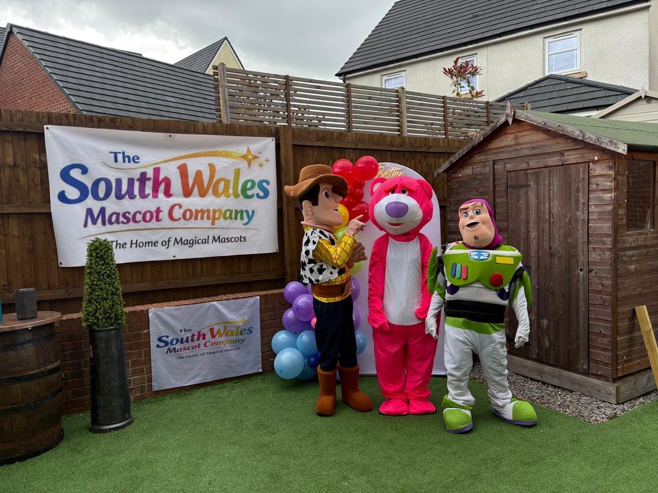 Woody, Lotso and Buzz lookalike mascots in a garden by a balloon garland
